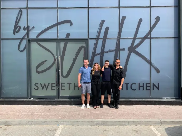 Notre co-fondateur Alex se tenant avec l'équipe de Sweatheart Kitchen